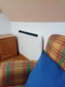 ein Zimmer mit einem Heizkörper und einer Couch in der Unterkunft Ático en pleno pirineo in El Pueyo de Jaca