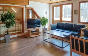 een woonkamer met een blauwe bank en een tv bij Lovely Home In Kpingsvik With Wifi in Köpingsvik