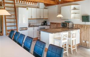 シーピンスリーにあるStunning Home In Kpingsvik With 5 Bedrooms, Sauna And Outdoor Swimming Poolのキッチン(椅子とテーブル付きのカウンター付)
