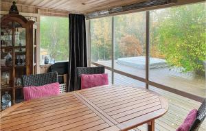 einen Holztisch und Stühle auf einer abgeschirmten Veranda in der Unterkunft Gorgeous Home In Huddinge With Wi-fi in Huddinge