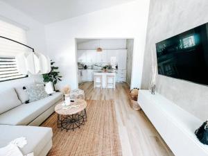 a white living room with a white couch and a table at Boho Style House Super Comfortable For 5@ San Juan rey 2 apt 1 in San Juan
