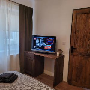 a bedroom with a desk with a television on it at Casa LADIS in Iernut