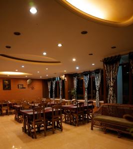 une salle à manger avec des tables et des chaises en bois dans l'établissement The Nest Inn Resort, à Masinagudi