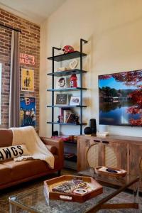 uma sala de estar com um sofá e uma televisão em UGA Penthouse Downtown Athens Walk To Stadium em Athens