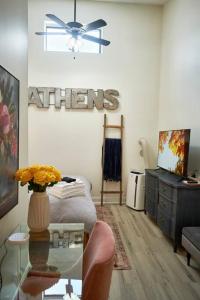 uma sala de estar com uma mesa e uma ventoinha de tecto em UGA Penthouse Downtown Athens Walk To Stadium em Athens