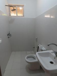 a bathroom with a toilet and a sink and a window at Drifters Zanzibar in Paje