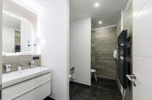La salle de bains blanche est pourvue d'un lavabo et d'un miroir. dans l'établissement Alte Seefahrtschule am Ostseestrand, à Wustrow