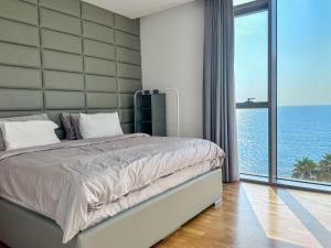a bedroom with a large bed with a view of the ocean at Fabulous full sea view 3br bluewaters Island in Dubai