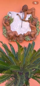 une horloge sur un mur avec un homme tenant une planche de surf dans l'établissement Agriturismo Podere Marchiano, à Larciano