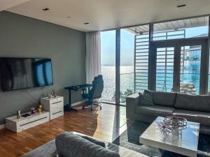 a living room with a couch and a tv and a table at Fabulous full sea view 3br bluewaters Island in Dubai