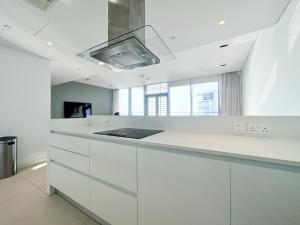 uma cozinha branca com armários brancos e um lavatório em Fabulous full sea view 3br bluewaters Island em Dubai
