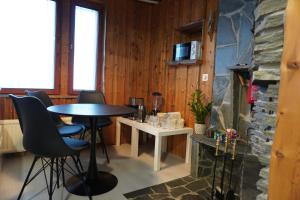 a table and chairs in a room with a fireplace at Your home away from home! in Rovaniemi