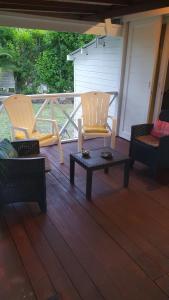 two chairs and a coffee table on a porch at Villa de Bois Blanc Strelitzia in Saint-Leu