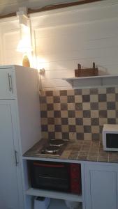a kitchen with a stove and a checkered counter top at Villa de Bois Blanc Strelitzia in Saint-Leu