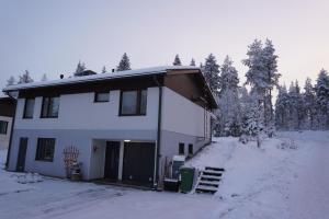 una casa blanca con un garaje en la nieve en Your home away from home!, en Rovaniemi