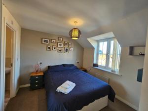 Un dormitorio con una cama azul y una ventana en Holly Crescent, Sacriston DH7, en Sacriston