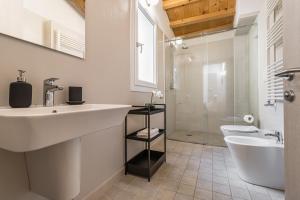 uma casa de banho com um lavatório, uma banheira e um WC. em Veronetta Stunning Rooftop with Lift em Verona