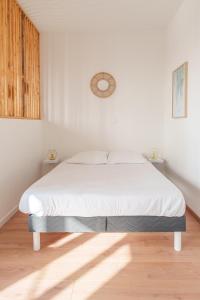 a white bedroom with a bed in a room at Le Fleur de Cerisier - ZMN Conciergerie in Saint-Quentin