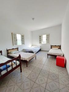 カラグアタトゥーバにあるCasa Prainha até 6 pessoasのベッド3台と窓2つが備わる客室です。