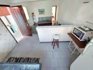 カラグアタトゥーバにあるCasa Prainha até 6 pessoasのキッチン(カウンター、テーブル付)が備わる客室です。