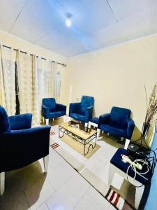 una sala de espera con sillas azules y una mesa en LNIMMO-LAGRACE-Studio calme avec internet illimité et forage, en Yaoundé