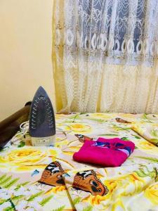 Una cama con secador de pelo y ropa. en LNIMMO-LAGRACE-Studio calme avec internet illimité et forage en Yaundé