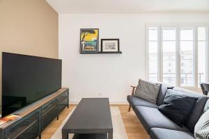 uma sala de estar com um sofá e uma televisão de ecrã plano em les LOFTS de Saint Clair Un balcon à Toulon LOFT 4CH CLIM 8 PAX MAX em Toulon