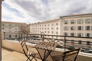 uma varanda com 2 cadeiras e vista para um edifício em les LOFTS de Saint Clair Un balcon à Toulon LOFT 4CH CLIM 8 PAX MAX em Toulon