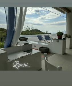 a patio with chairs and a table and a view of the water at Casa al tramonto...sunset lovers retreat in Lipari +41 photos