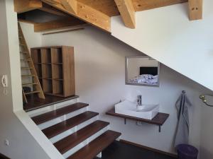 ein Badezimmer mit einem Waschbecken und eine Treppe mit einem Waschbecken in der Unterkunft Apartment Katalin in Murau