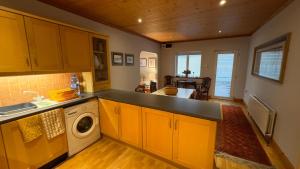 a kitchen with a sink and a washing machine at Cosy home in a beautiful valley in Tipperary