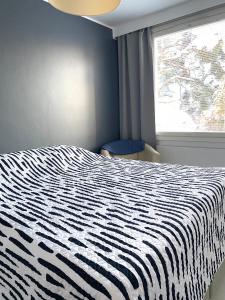 - une chambre avec un lit noir et blanc et une fenêtre dans l'établissement Huttunen - Ihqu kolmio loistavalla sijainnilla, à Iisalmi