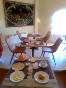 uma sala com mesas e cadeiras com comida em El Refugio Bed & Breakfast em Villarrobledo