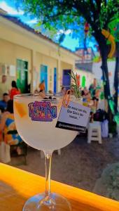 a drink in a wine glass sitting on a table at Hostel Recife Bar quartos climatizados das 22h às 6h in Recife
