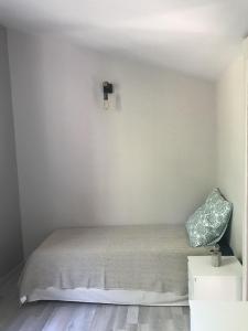 德拉吉尼昂的住宿－Grain de Paille，一间卧室设有一张床和白色的墙壁