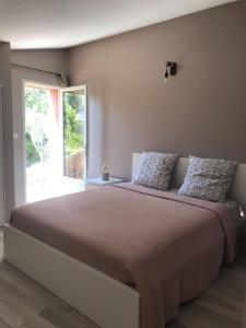 Schlafzimmer mit einem großen Bett und einem Fenster in der Unterkunft Grain de Paille in Draguignan