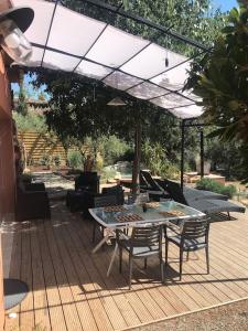 eine Terrasse mit einem Tisch und Stühlen unter einem Sonnenschirm in der Unterkunft Grain de Paille in Draguignan