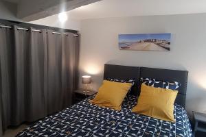 um quarto com uma cama com almofadas amarelas em Gite Douar Armor le 28 em Dinan