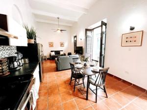 a kitchen and living room with a table and chairs at 65 Fortaleza 1 - N Colonial Apt W/ Balconies & Views in San Juan