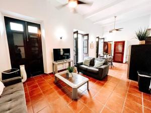 65 Fortaleza 1 - N Colonial Apt W/ Balconies & Views في سان خوان: غرفة معيشة مع أريكة وطاولة قهوة