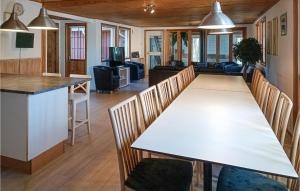Amazing Home In Kpingsvik With Sauna في كوبينغسفيك: غرفة طعام وغرفة معيشة مع طاولة وكراسي بيضاء