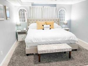 una camera bianca con un grande letto e una panca di La Casita a Freeport