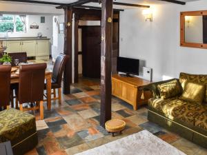a living room with a couch and a dining room at Stores Cottages in Ludham