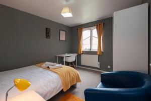 een slaapkamer met een bed, een stoel en een bureau bij Cosy 2 BDR Flat with Free Parking close to Tower Bridge in Londen