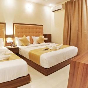 una habitación de hotel con 2 camas en una habitación en Hotel Emerald Near T2 International Airport Mumbai, en Bombay