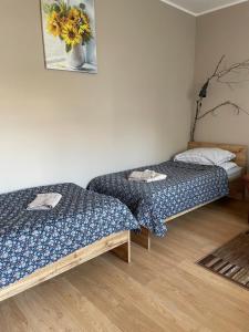 Zimmer mit 2 Betten und einer Blumenvase in der Unterkunft Domek na skraju lasu in Uniejów