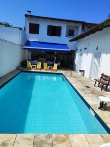a swimming pool in front of a house at Pousada Sol da Manhã in Guarujá