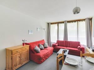 a living room with a red couch and a table at Appartement La Mongie, 2 pièces, 5 personnes - FR-1-404-57 in La Mongie