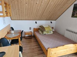 a small bedroom with a bed and a wooden ceiling at Pokoje u Joli Polańczyk in Polańczyk