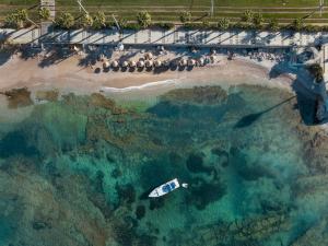 an aerial view of a boat in the water near a beach at Coral Hotel Athens in Athens